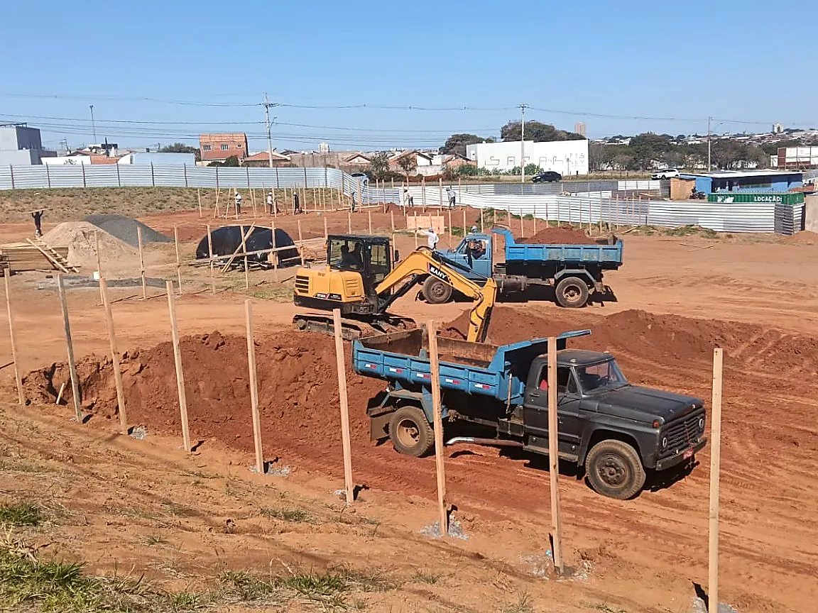 Escavadeira carregando caminhão em obra