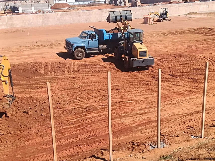 Pá carregadeira e caminhão em obra de terraplanagem